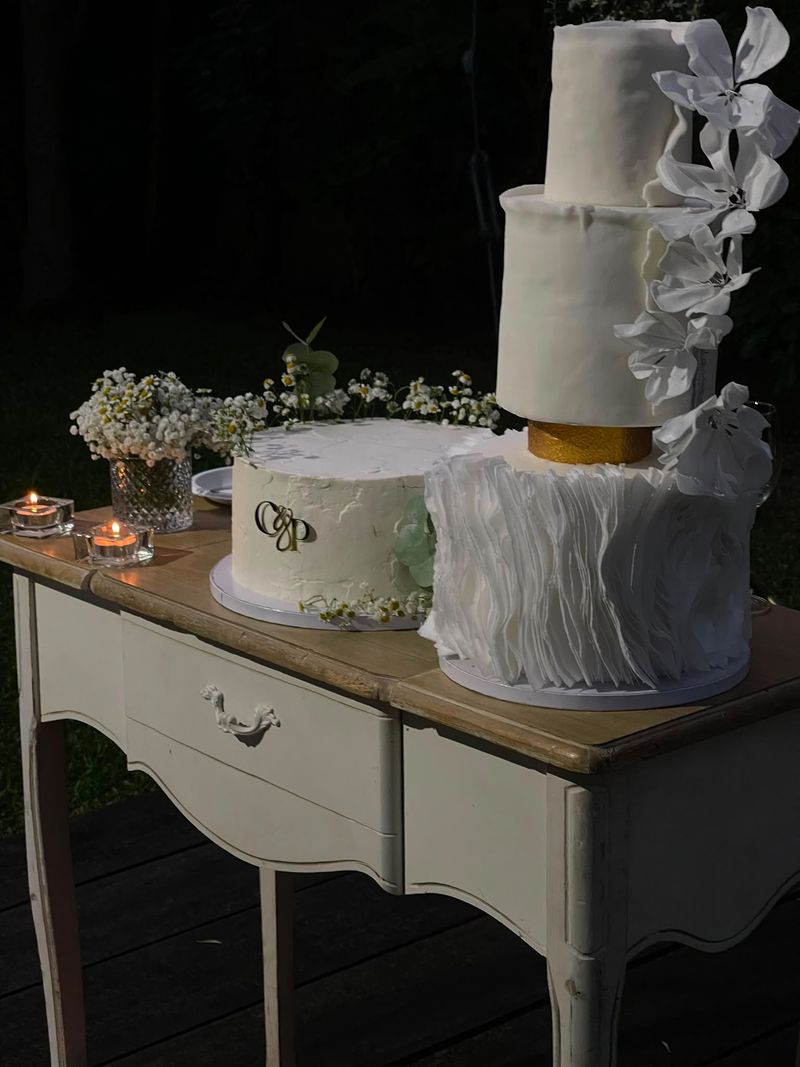 Bolo de casamento de dois andares com orquídeas e bolo com monograma
