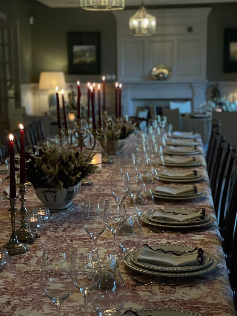Mesa comprida com velas e toalha estampada