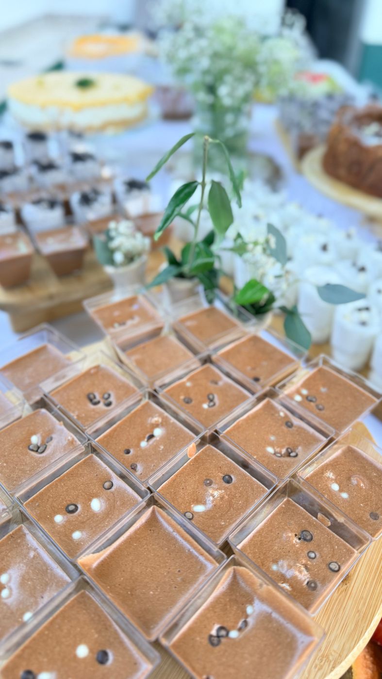Copinhos de mousse de chocolate alinhados na mesa de doces